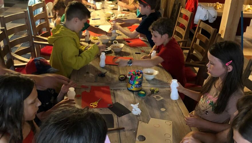 Dzieci malują farbami przy długim stole