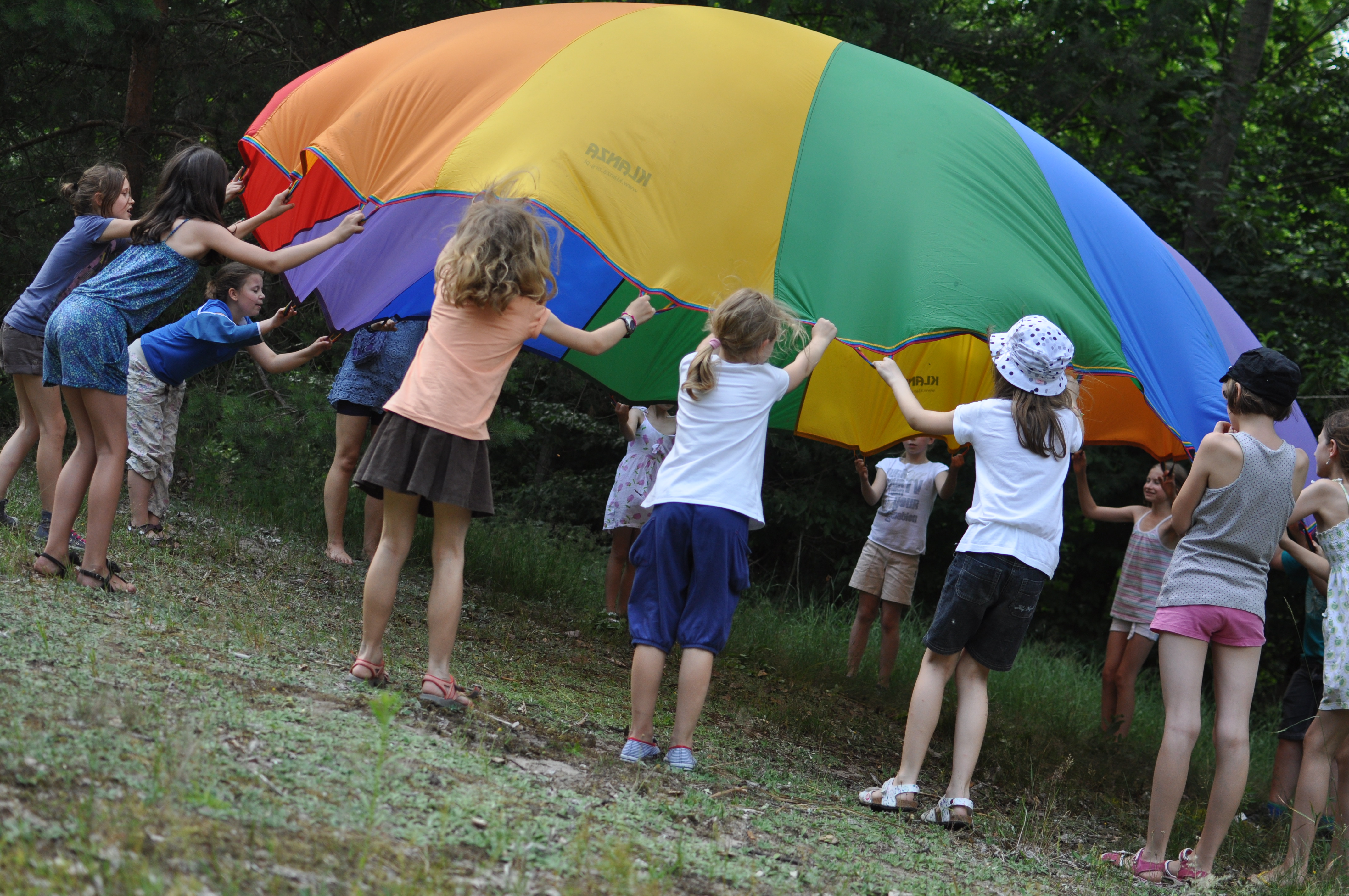 Dzieci bawiące się kolorową chustą