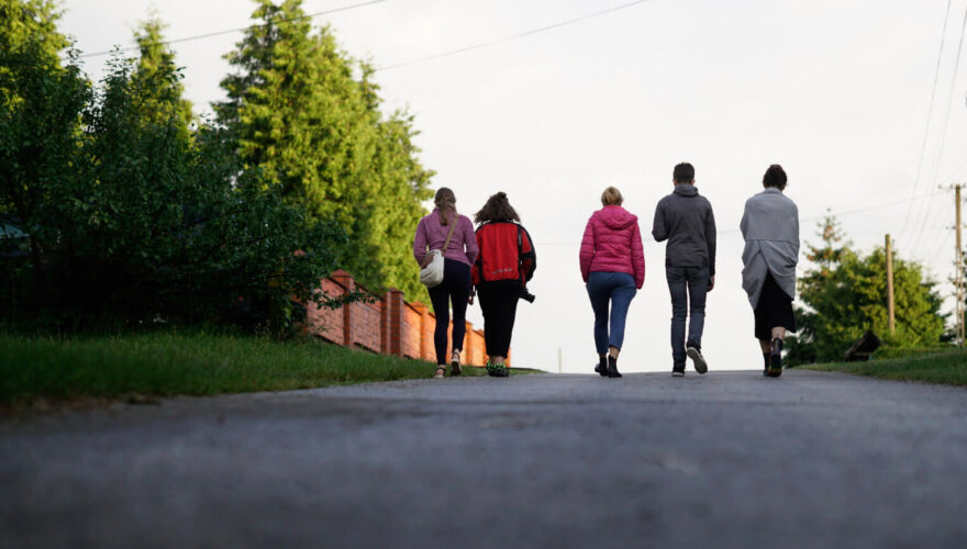 młodzi ludzie spacerują ulicą, nie widać twarzy