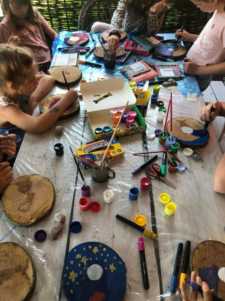 Dzieci przy stole malują farbkami