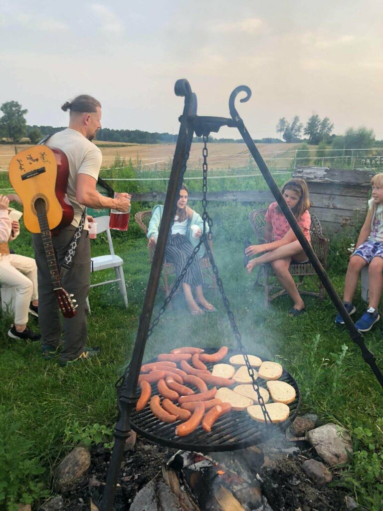 Dzieci siędzące przy grilu i Pan z gitarą