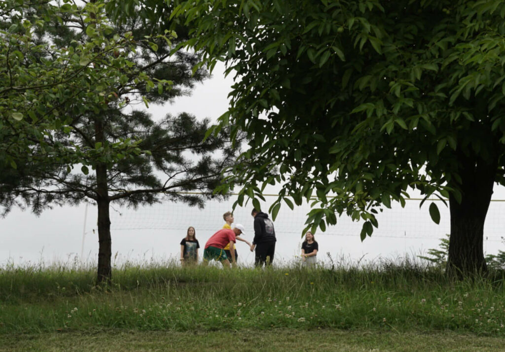 dzieci wśród zieleni graja w siatkówkę